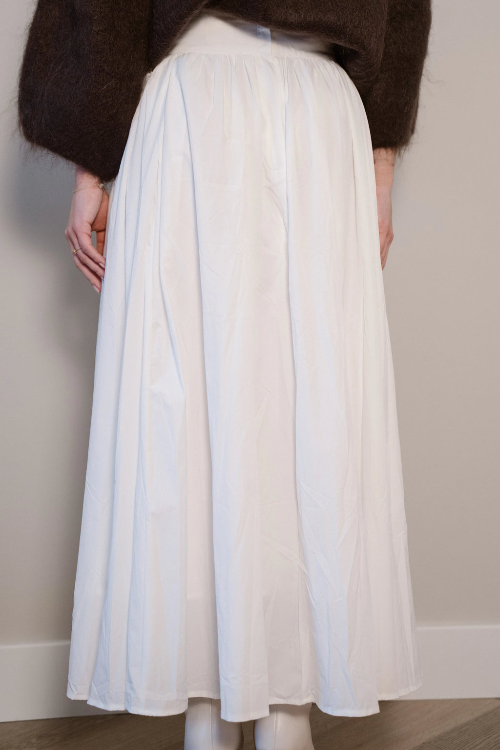 Lange witte rok met plooien en een vloeiende, elegante pasvorm.