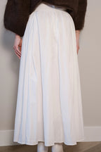Lange witte rok met plooien en een vloeiende, elegante pasvorm.