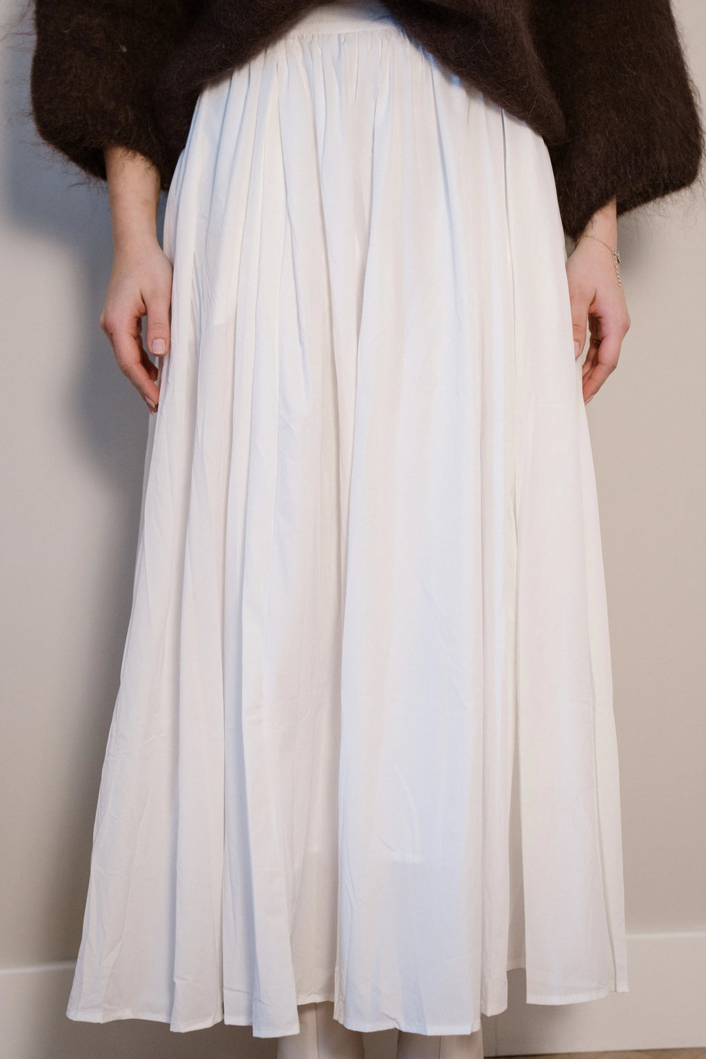 Lange witte rok met plooien en een vloeiende, elegante pasvorm.